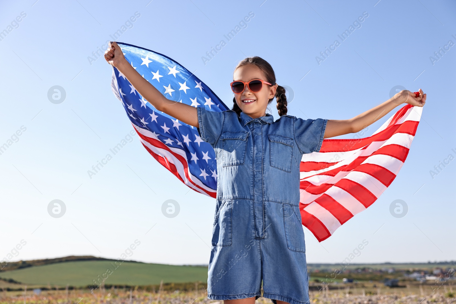 Photo of Happy girl with flag of USA outdoors