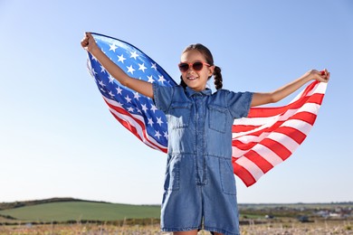 Happy girl with flag of USA outdoors