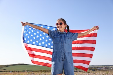 Happy girl with flag of USA outdoors