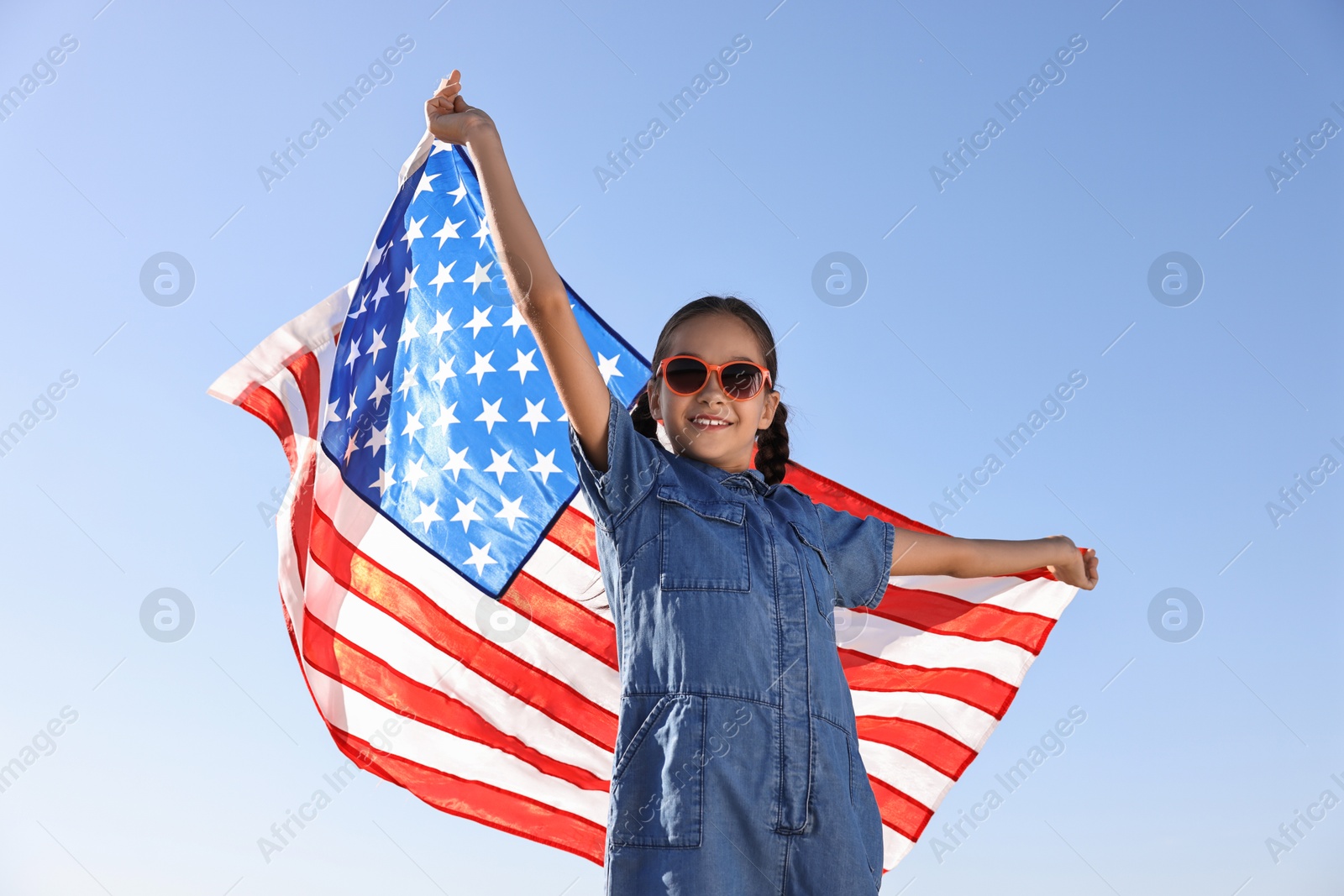 Photo of Happy girl with flag of USA outdoors