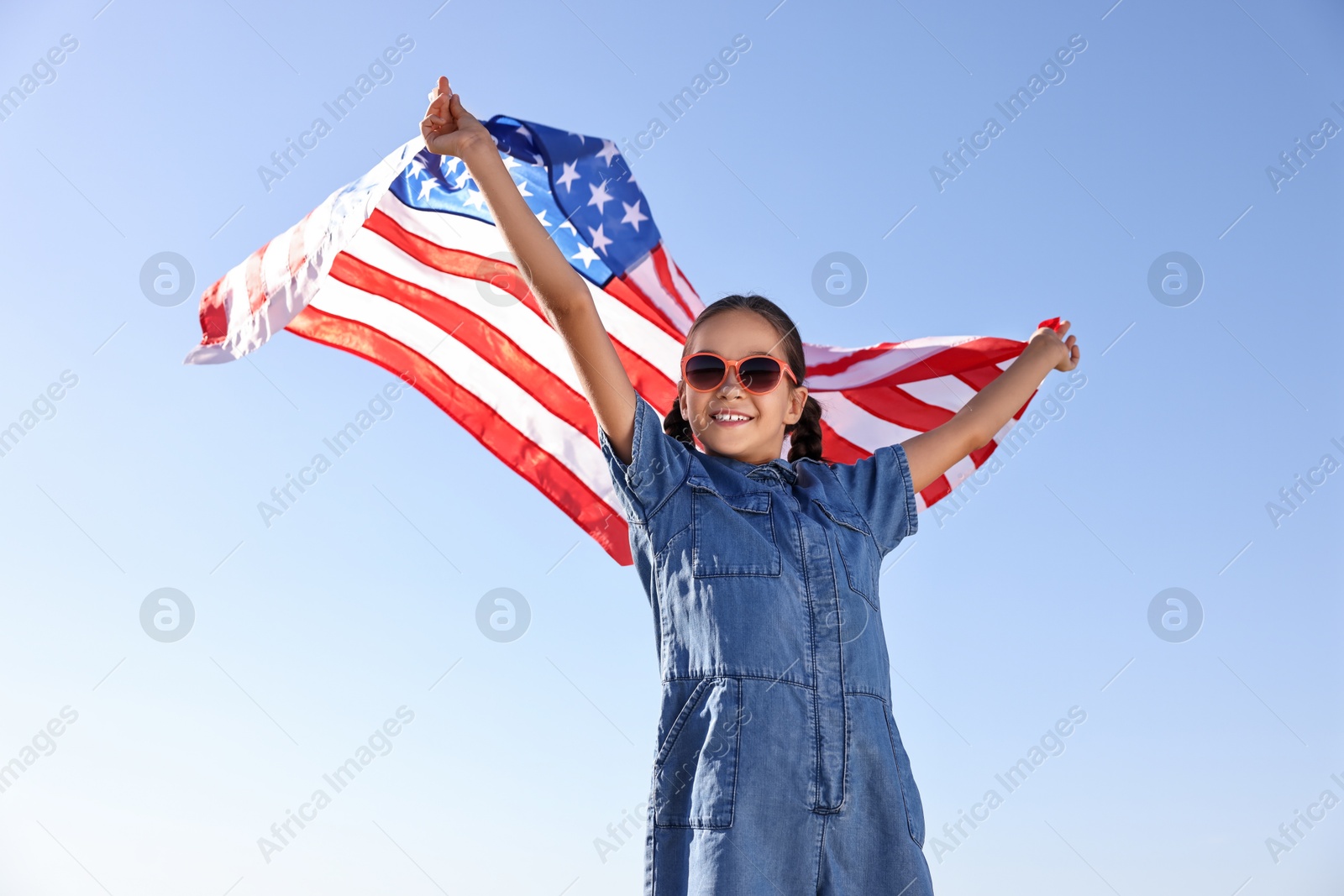 Photo of Happy girl with flag of USA outdoors