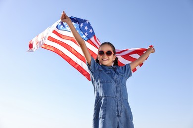 Photo of Happy girl with flag of USA outdoors