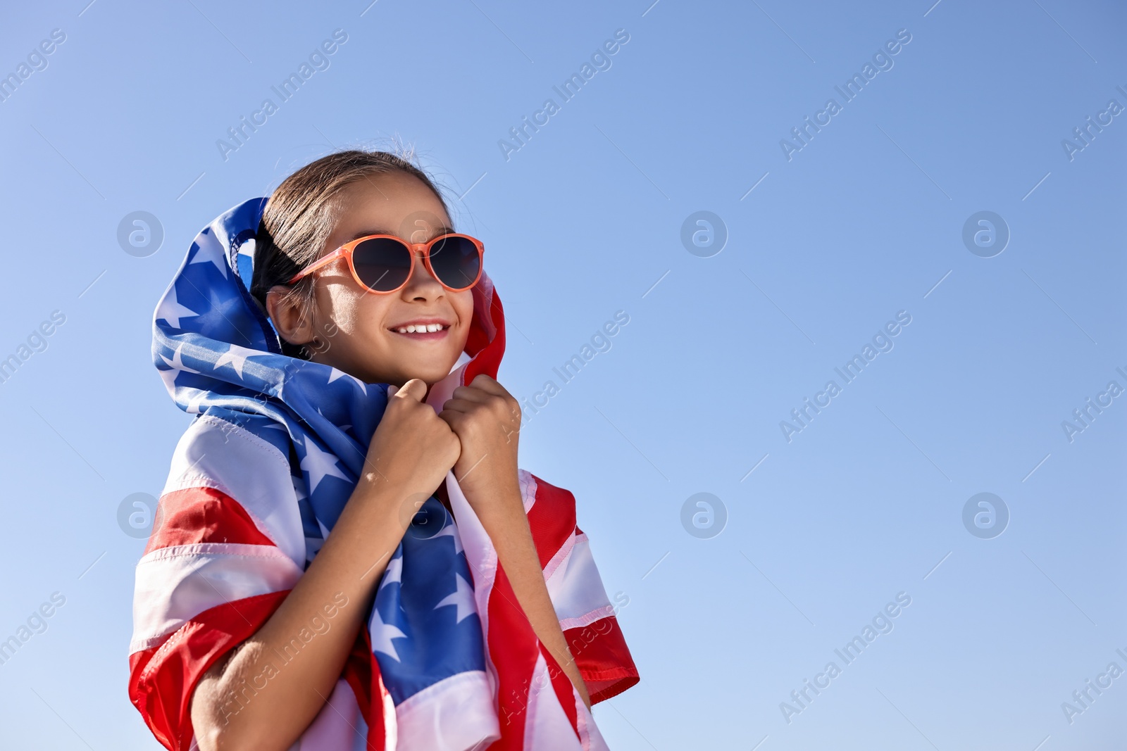 Photo of Happy girl with flag of USA outdoors. Space for text