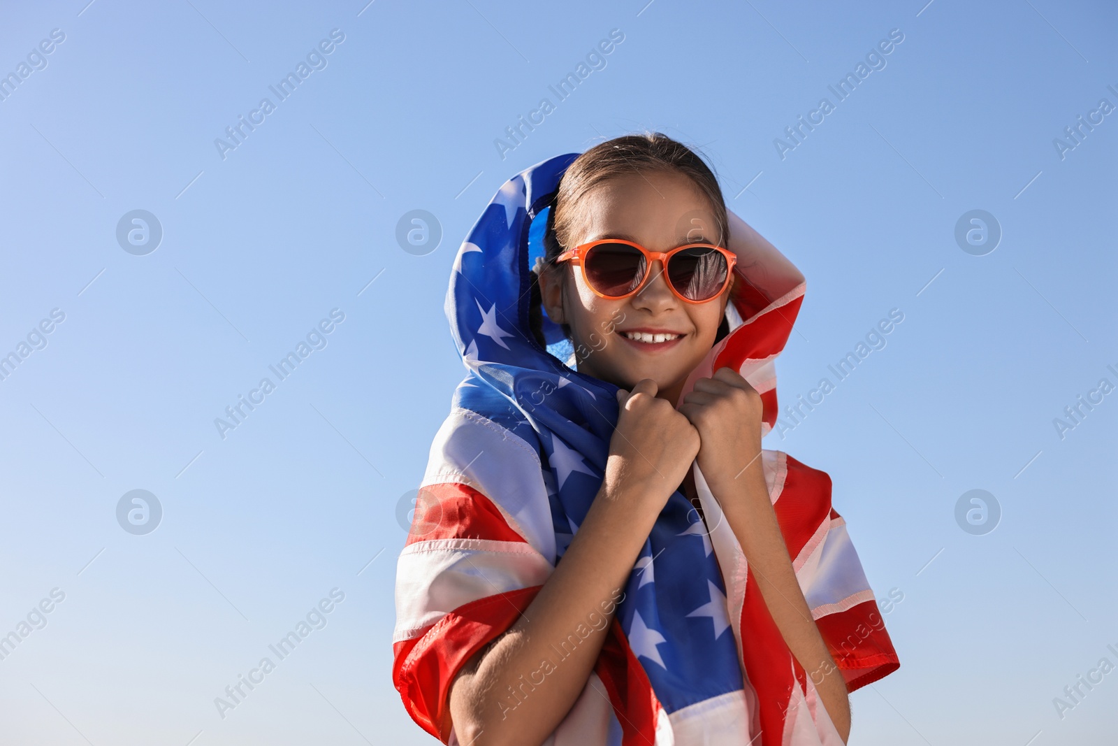 Photo of Happy girl with flag of USA outdoors. Space for text