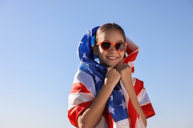 Photo of Happy girl with flag of USA outdoors. Space for text