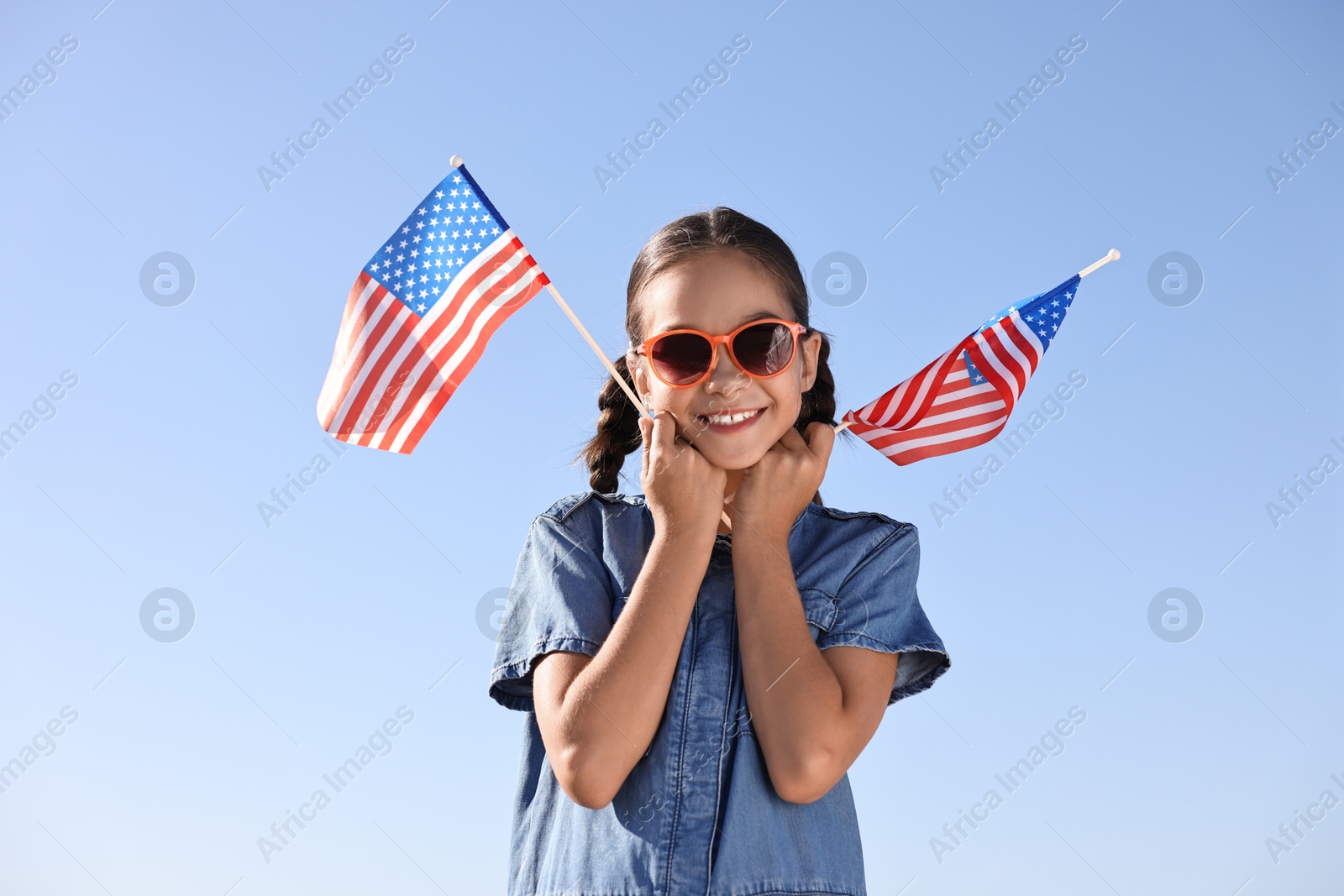 Photo of Happy girl with flags of USA outdoors