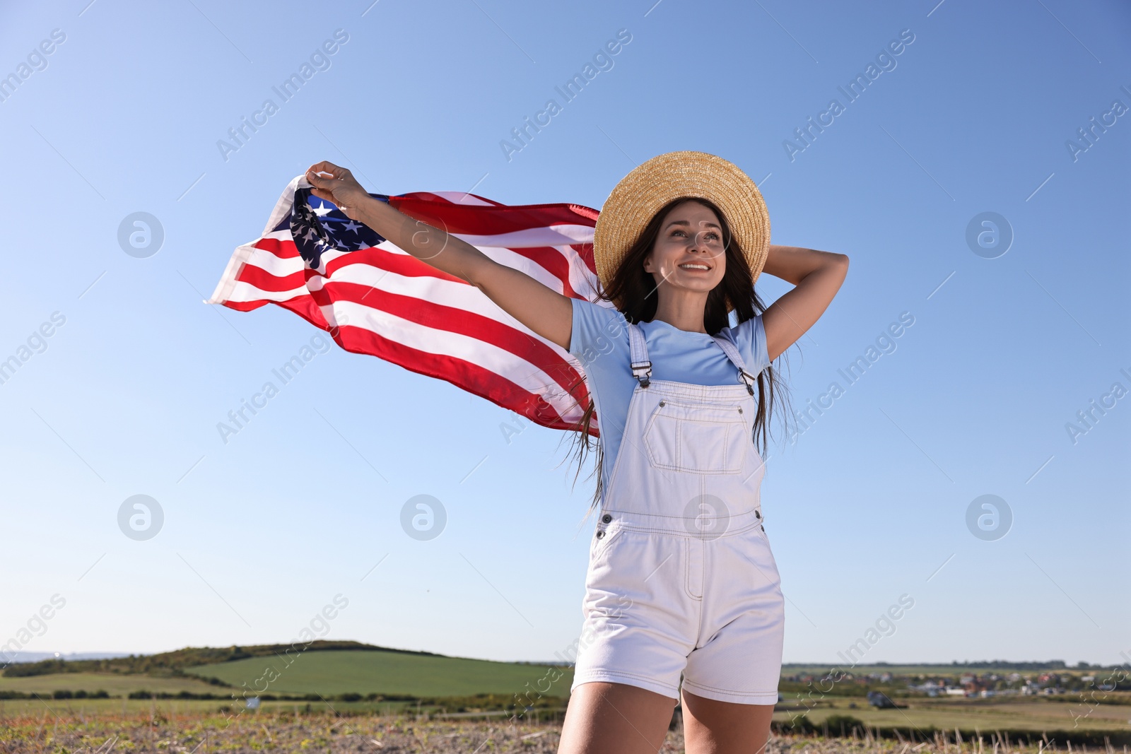 Photo of Happy woman with flag of USA outdoors