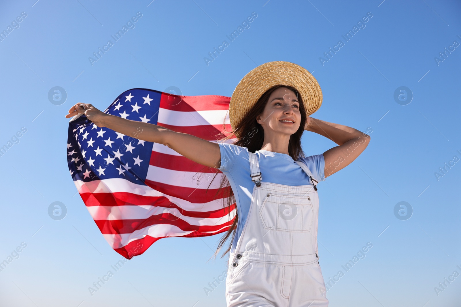 Photo of Happy woman with flag of USA outdoors