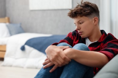 Photo of Loneliness concept. Sad teenage boy in bedroom, space for text