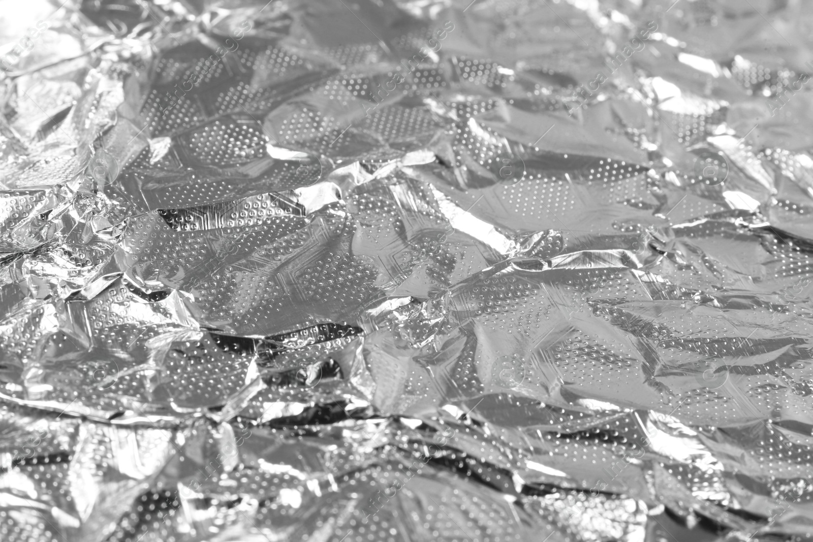 Photo of Shiny silver tinfoil surface as background, closeup