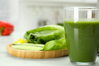 Delicious smoothie and ingredients on white table, closeup