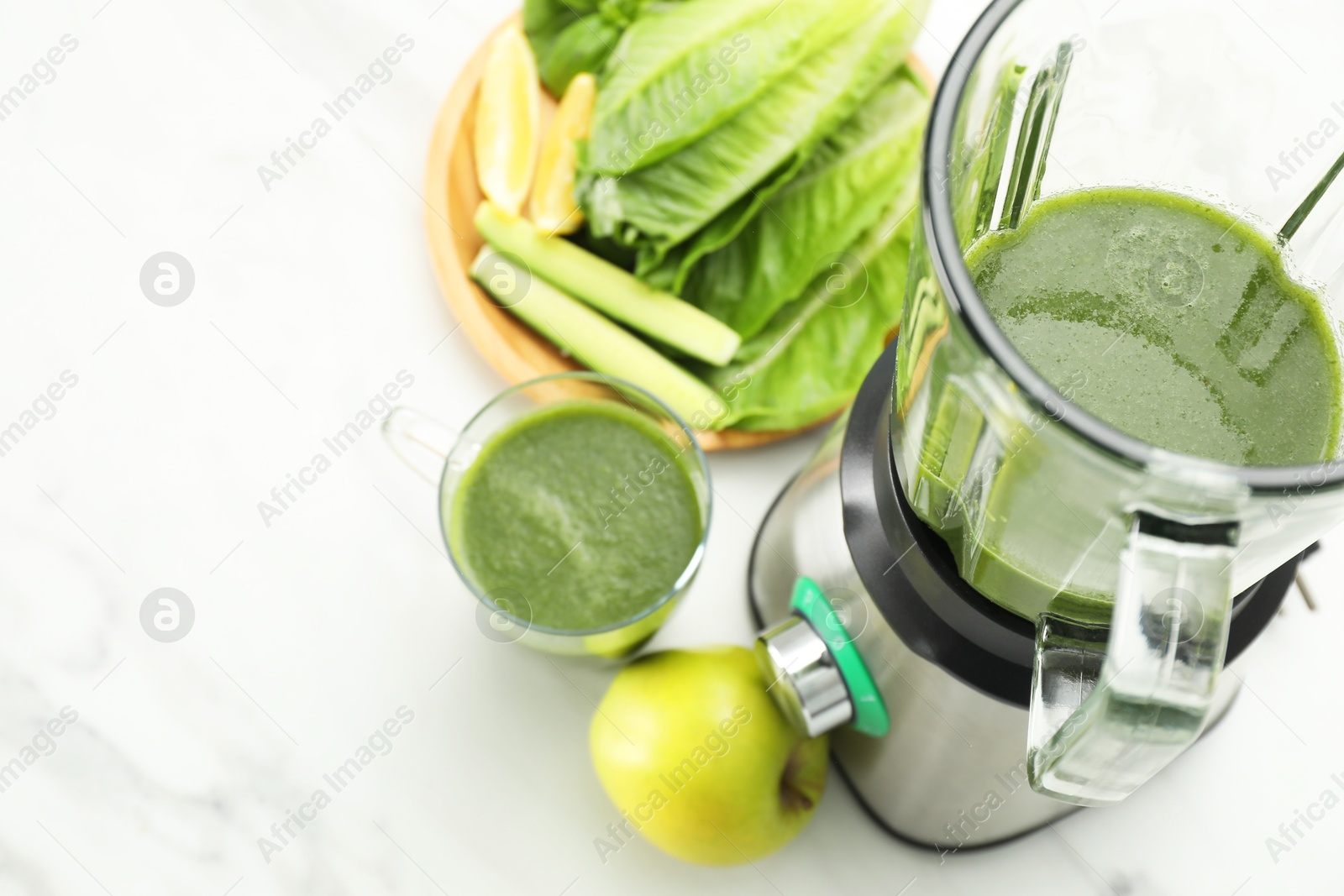 Photo of Modern blender with smoothie and ingredients on white marble table, above view. Space for text