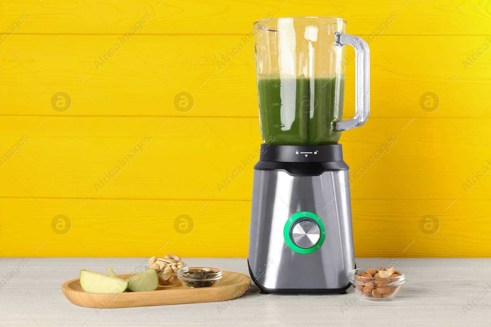 Photo of Modern blender with smoothie and ingredients on light wooden table. Space for text