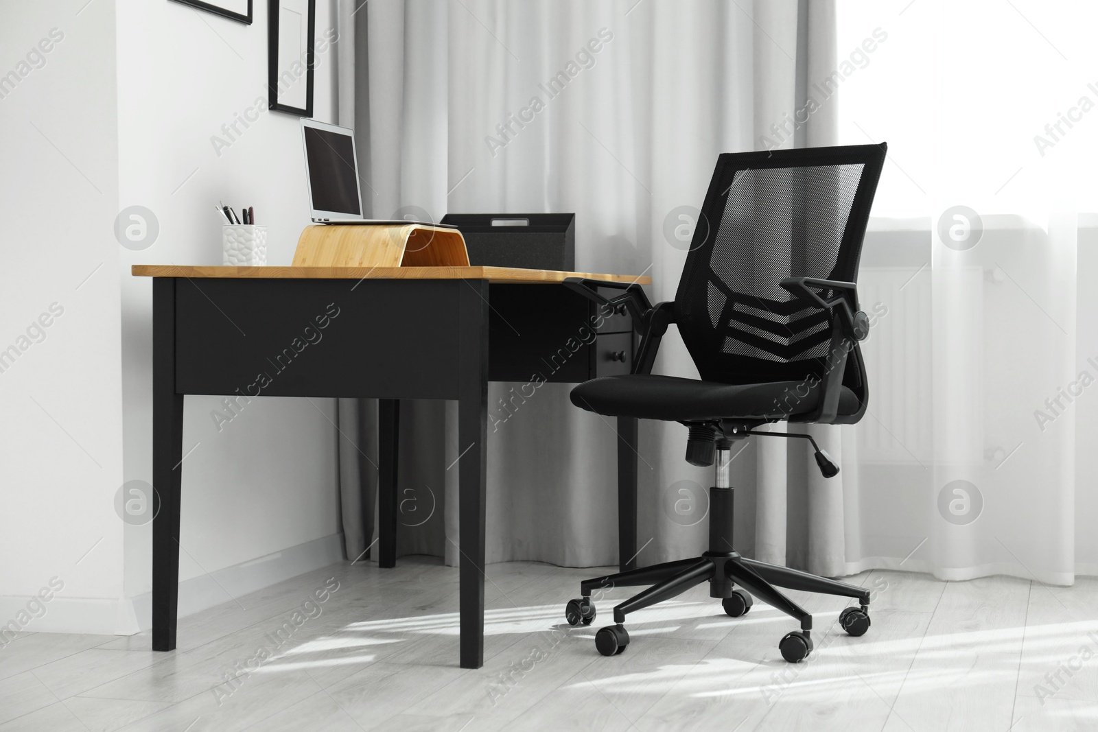 Photo of Black chair, laptop and desk in office