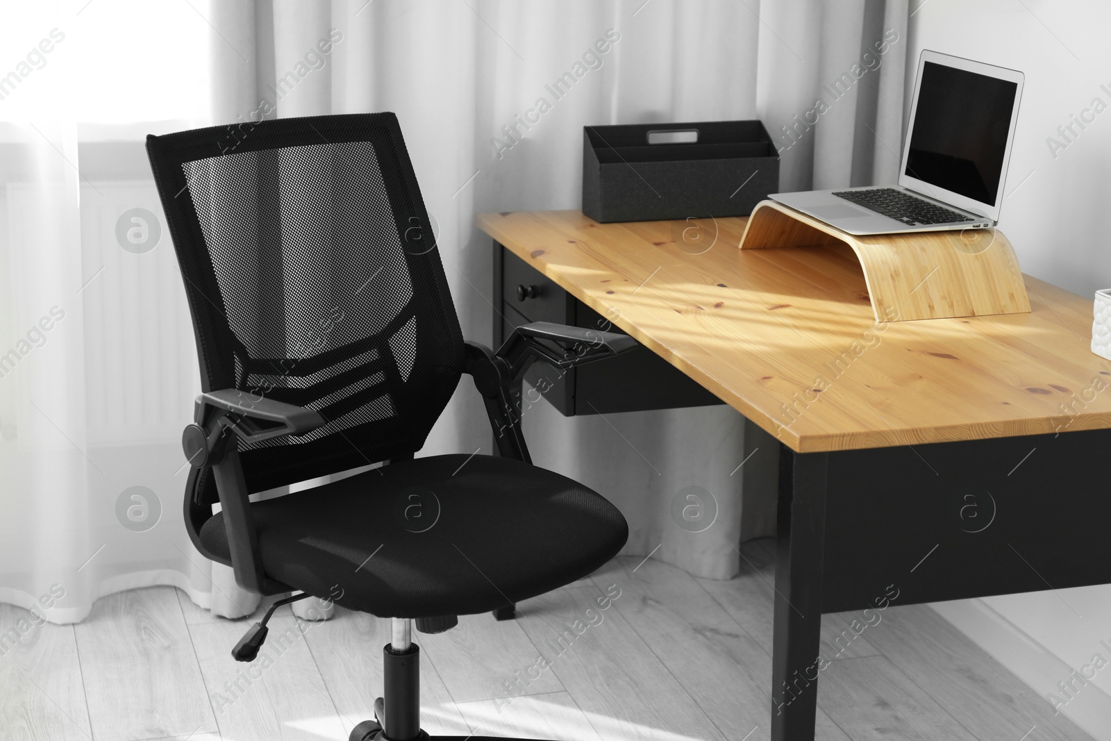 Photo of Black chair, laptop and desk in office