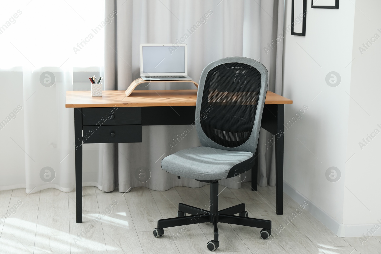 Photo of Grey chair, laptop and desk in office