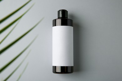 Photo of Bottle of shampoo on grey background, top view