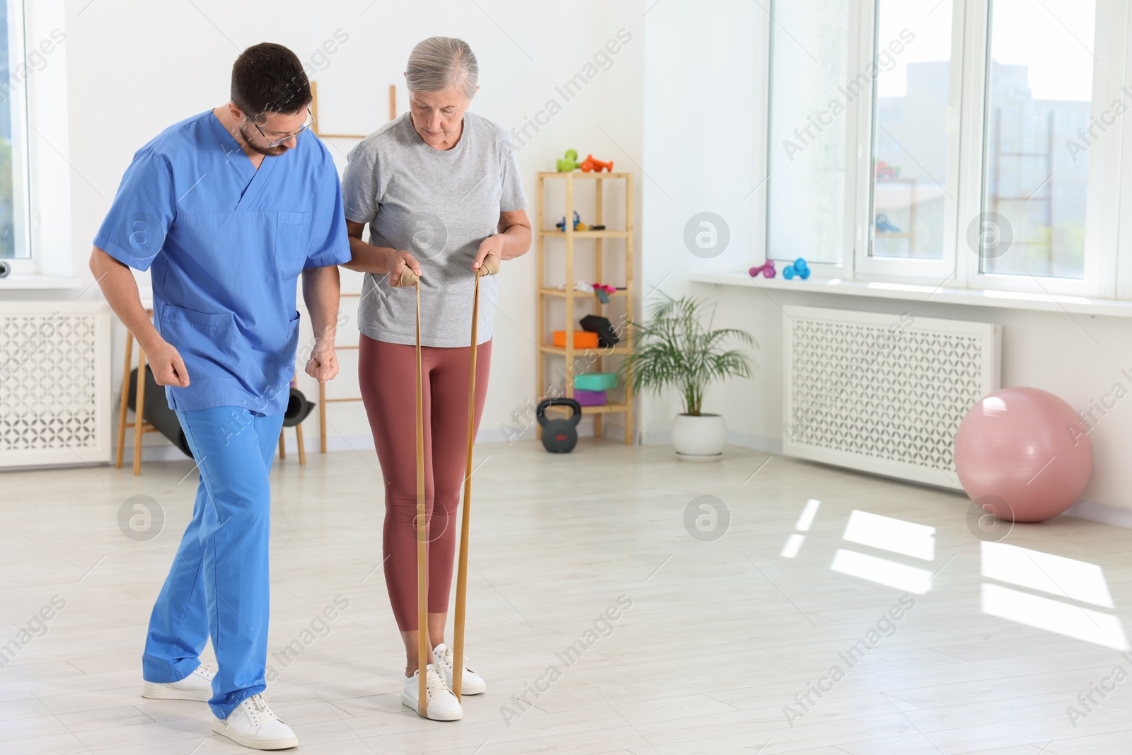 Photo of Senior patient exercising under physiotherapist supervision in rehabilitation center