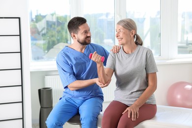 Senior patient exercising under physiotherapist supervision in rehabilitation center