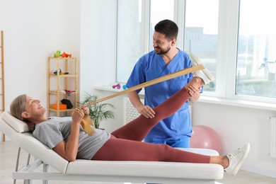 Photo of Physiotherapist working with senior patient in rehabilitation center