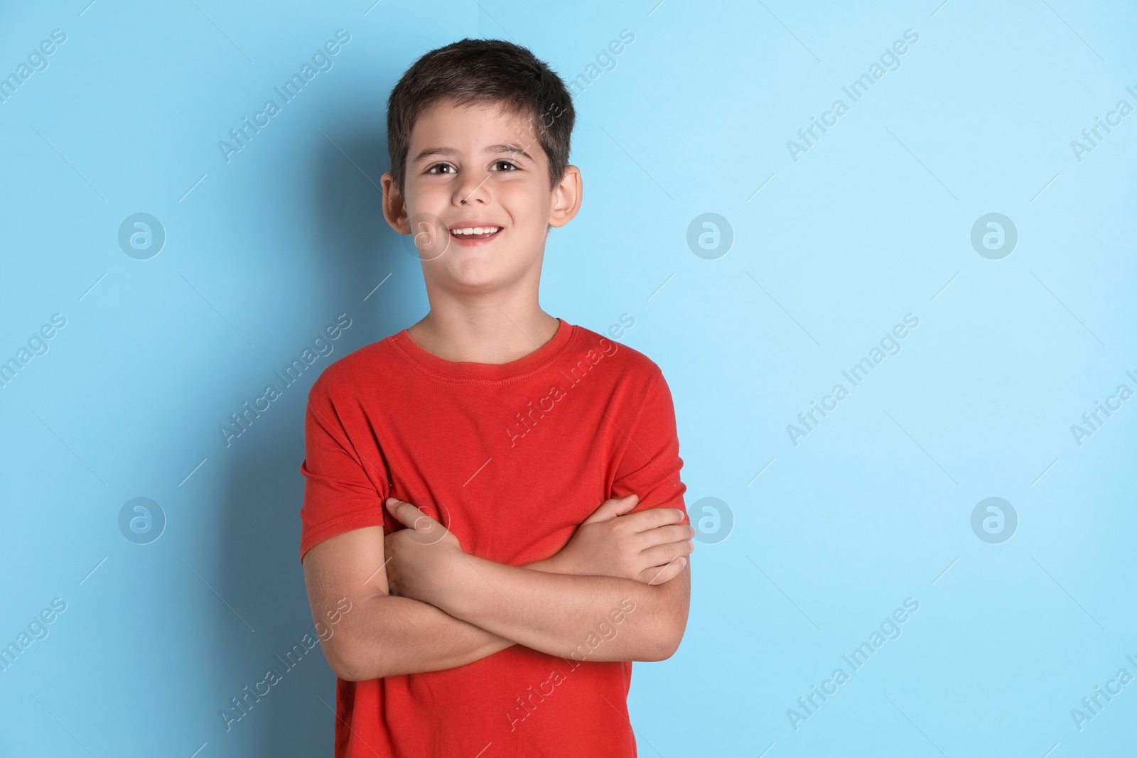 Photo of Portrait of cute little boy on light blue background