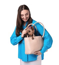 Beautiful young woman carrying cute Yorkshire Terrier dog in bag isolated on white