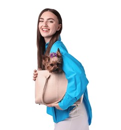 Beautiful young woman holding bag with cute Yorkshire Terrier dog isolated on white