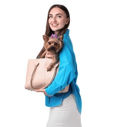 Beautiful young woman holding bag with cute Yorkshire Terrier dog isolated on white