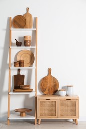 Photo of Storage stand and cabinet with kitchenware near white wall indoors