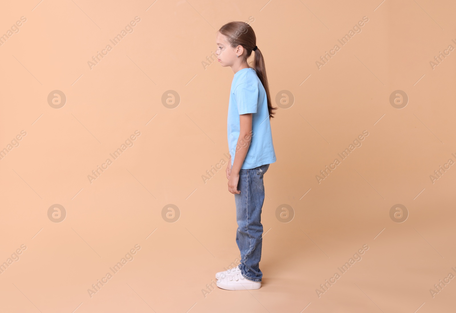 Photo of Girl with incorrect posture on beige background