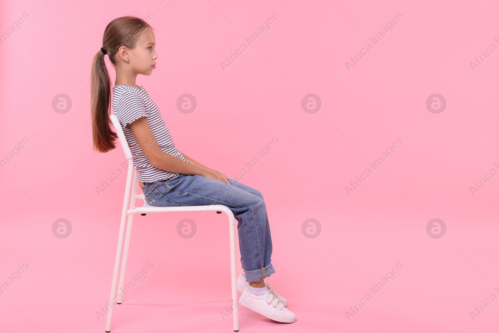 Photo of Girl with correct posture sitting on chair against pink background, space for text