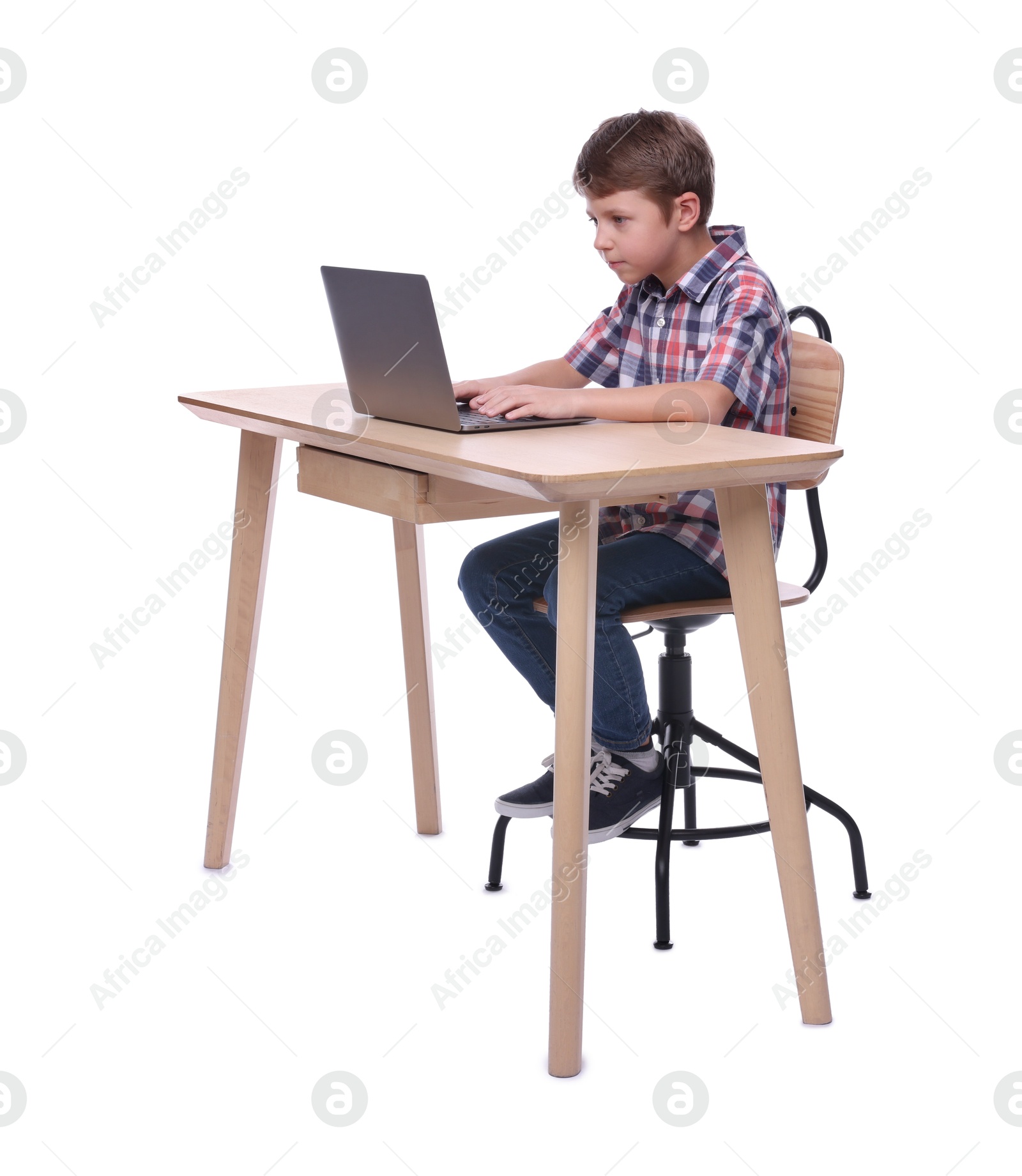 Photo of Boy with incorrect posture using laptop at wooden desk on white background