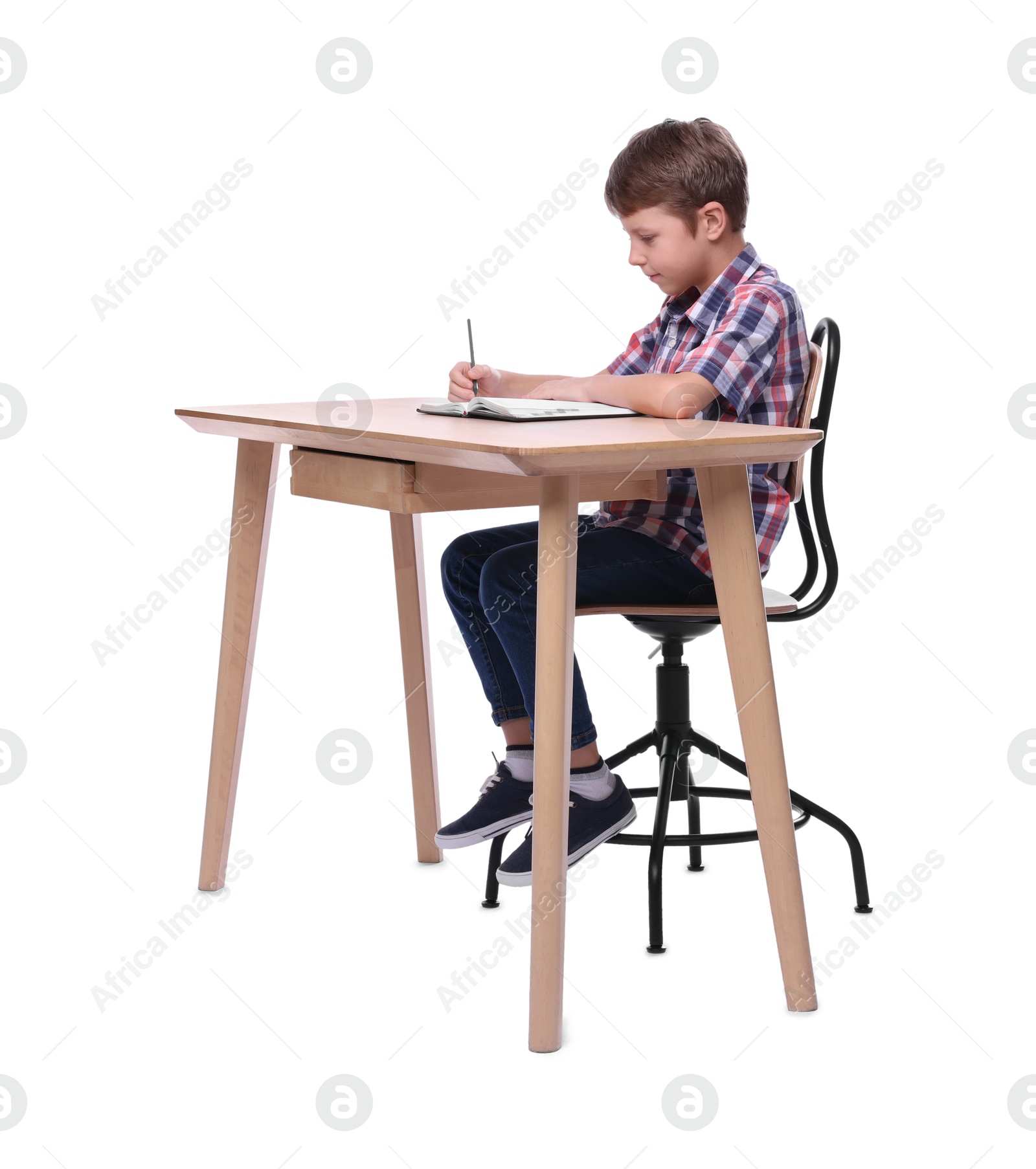 Photo of Boy with correct posture and notebook at wooden desk on white background