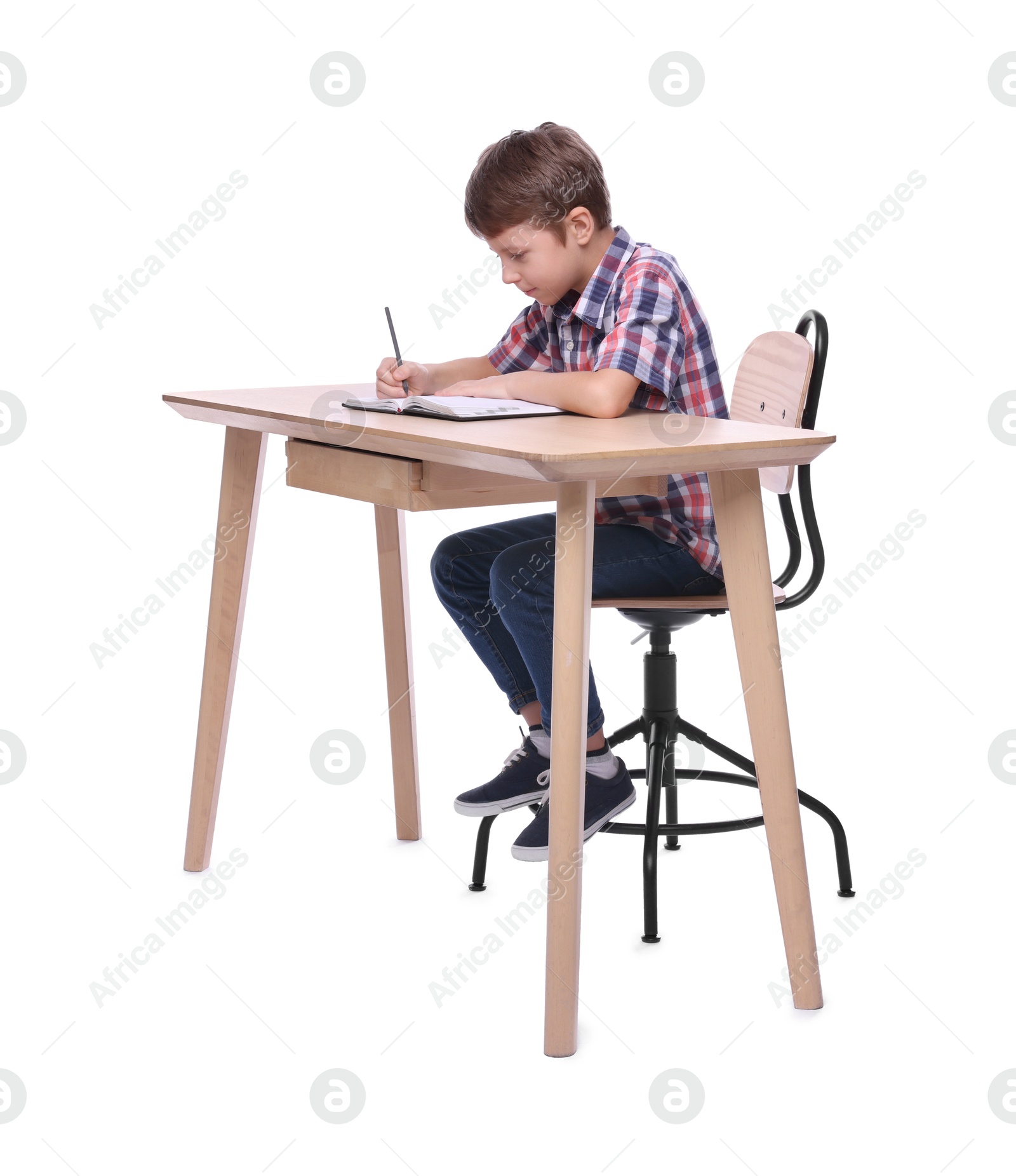 Photo of Boy with incorrect posture and notebook at wooden desk on white background