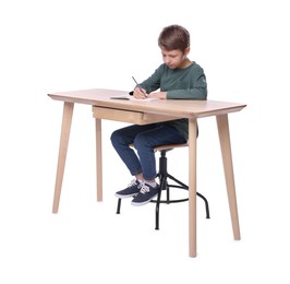 Boy with correct posture and notebook at wooden desk on white background