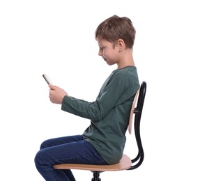 Boy with correct posture and phone sitting on chair against white background