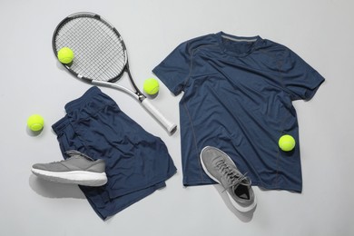 Photo of Tennis racket, balls and sportswear on light background, flat lay