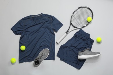 Photo of Tennis racket, balls and sportswear on light background, flat lay