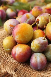 Photo of Pile of tasty ripe plums on table, closeup