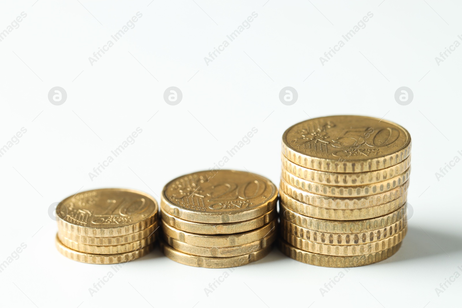 Photo of Stacked euro coins on white background, closeup