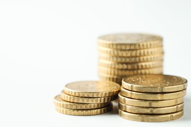 Photo of Stacked euro coins on white background, closeup