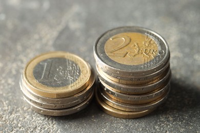 Photo of Stacked euro coins on grey table, closeup