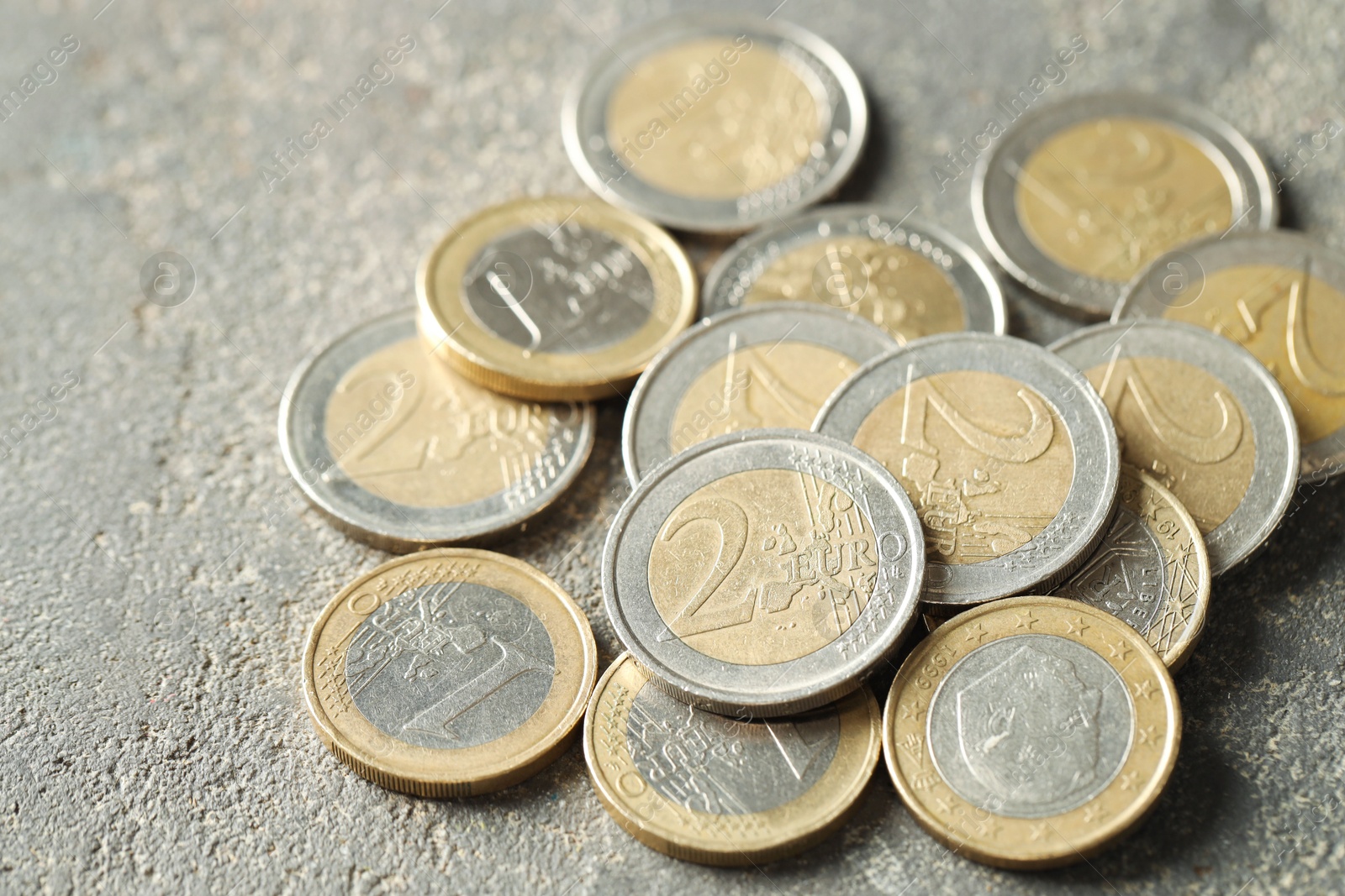 Photo of Many euro coins on grey table, closeup