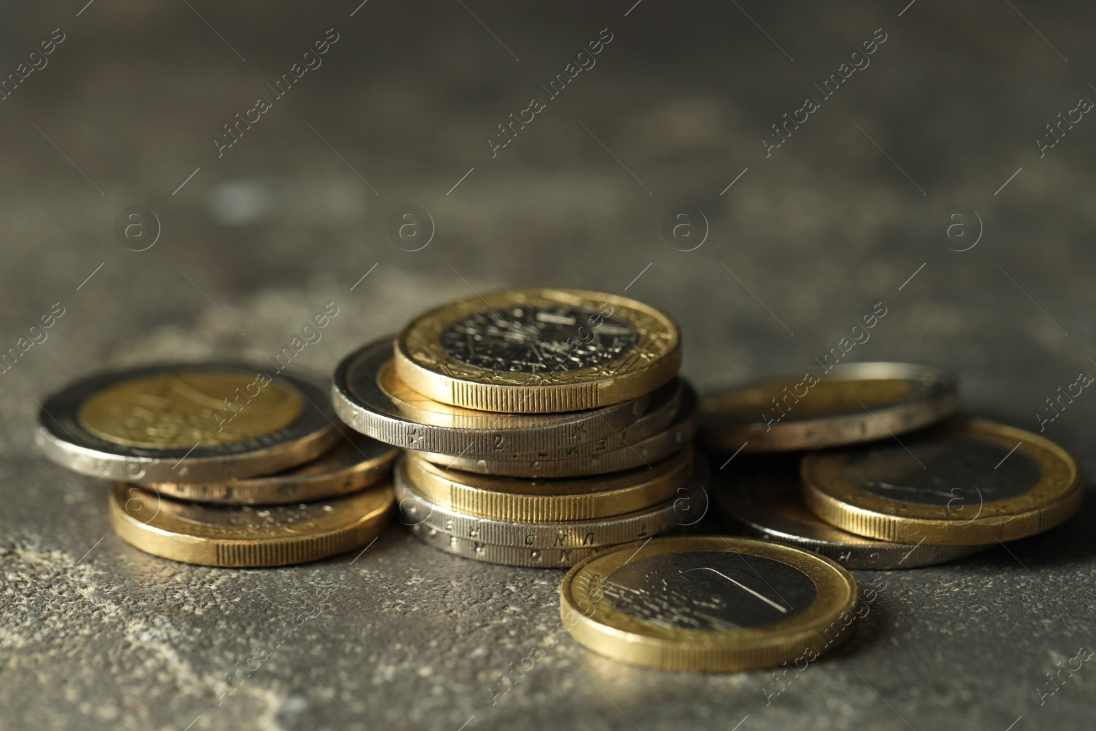 Photo of Many euro coins on grey table, closeup