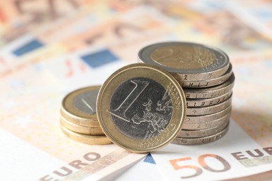 Many coins on euro banknotes, closeup view