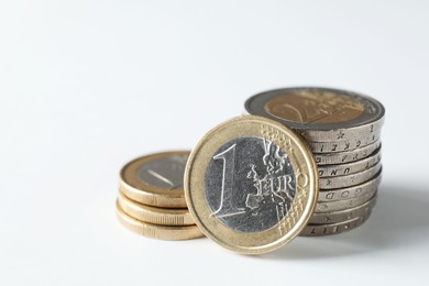 Photo of Stacked euro coins on white background, closeup