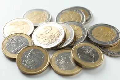 Photo of Many euro coins on white background, closeup