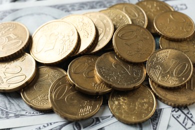 Photo of Many euro coins on dollar banknotes, closeup