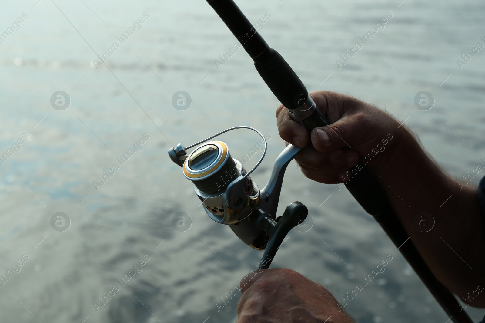 Photo of Fisherman with rod fishing near lake at summer, closeup