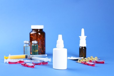 Photo of Pharmacist. Bottles of medical drops, pills ampoules and syringes on blue background